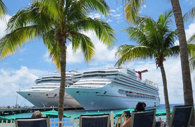 2 navios de cruzeiro em um dia ensolarado, com céu azul.